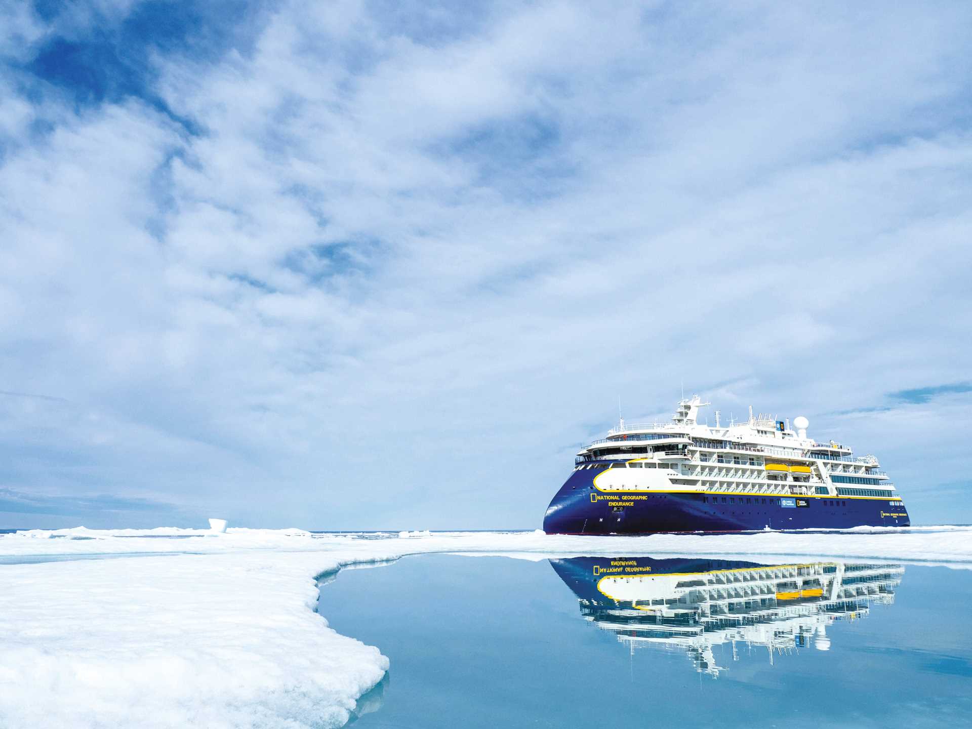 National geographic endurance in front of a large iceberg